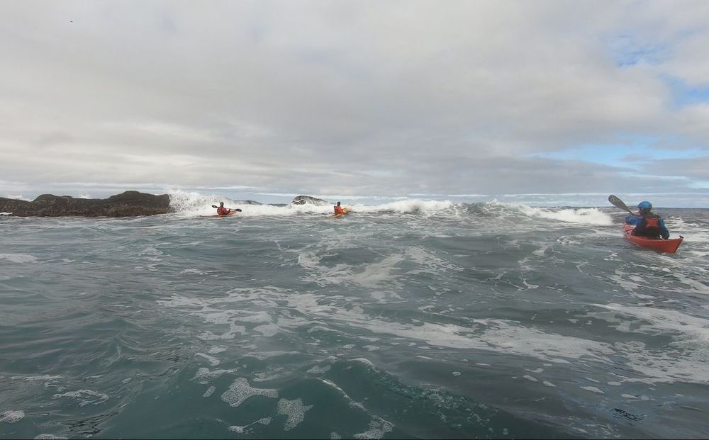 Kajakkpadlere i brenningene ved kysten, brottpadling i bølger på Nordvestlandet