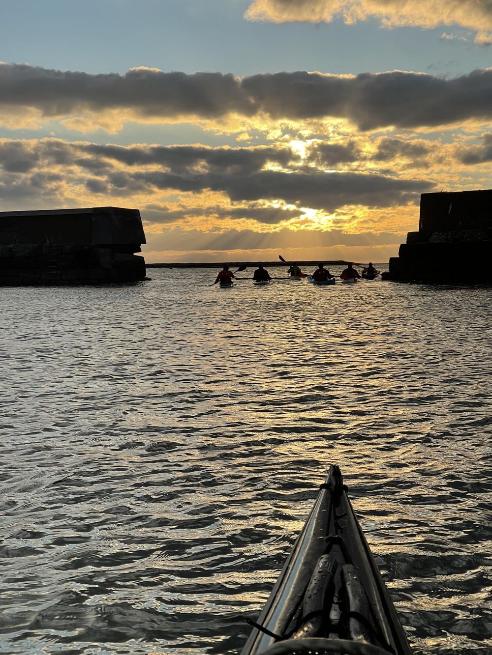 Kveldspadling mot solnedgang ved moloen