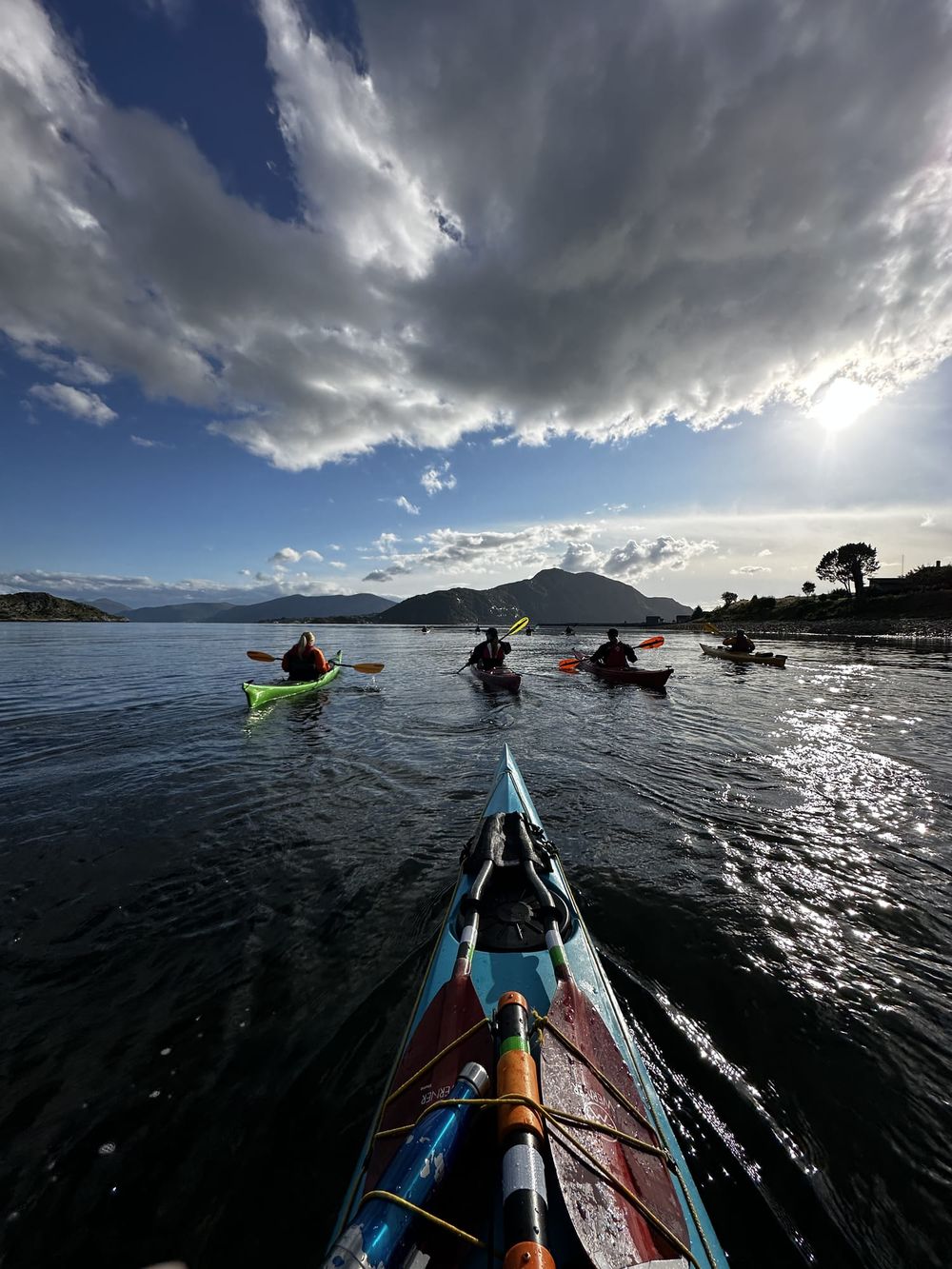 Padlegruppe på fjorden under dramatisk skyhimmel