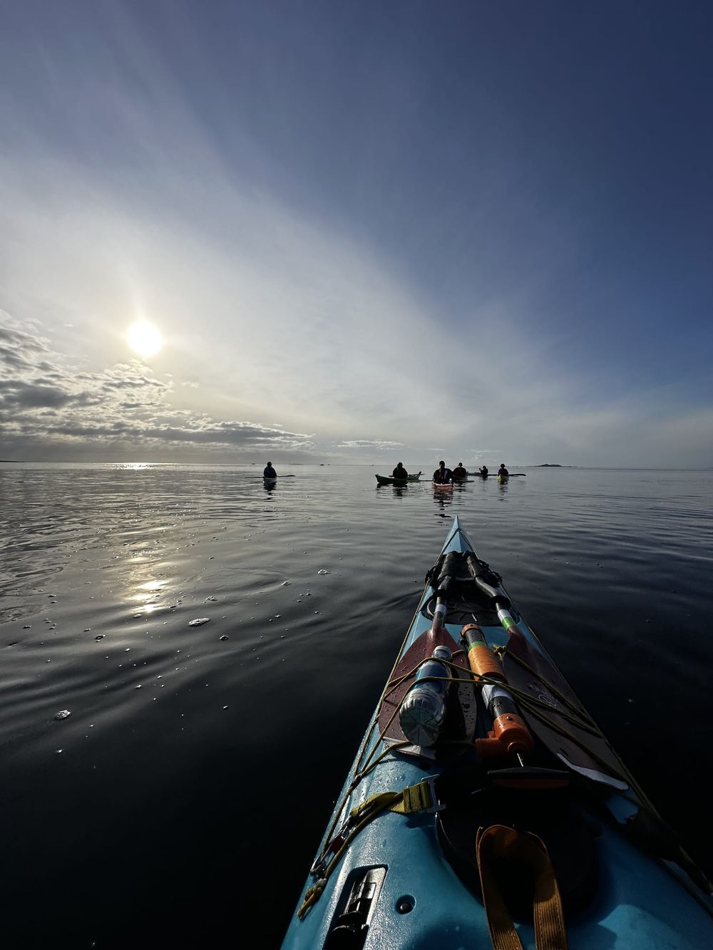 Padlegruppe i motlys med solrefleks på havet