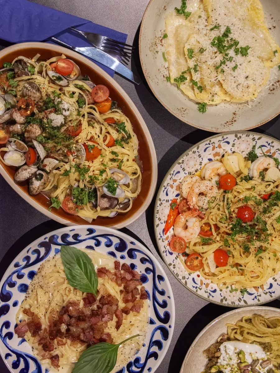 Flere av Pasta Vino sine pastaretter samlet på bordet